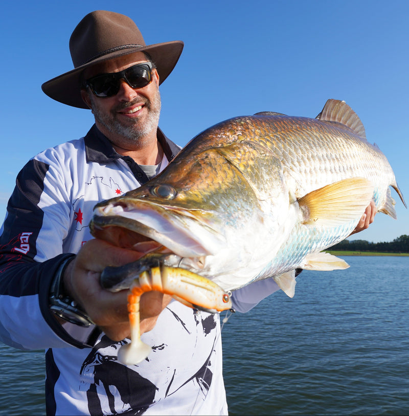 Mark Berg holing a barramundi with a soft plastic in it's mouth